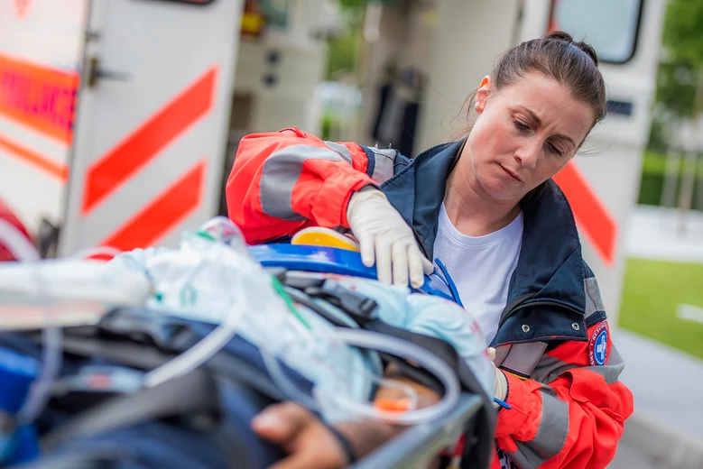 Notfallsanitäterin versorgt Patienten am Rettungswagen. Notfallsanitäter leisten lebensrettende Erstversorgung, führen Notfallmaßnahmen durch, betreuen Patienten beim Transport und sind erste Hilfe bei medizinischen Notfällen und Unfällen.
