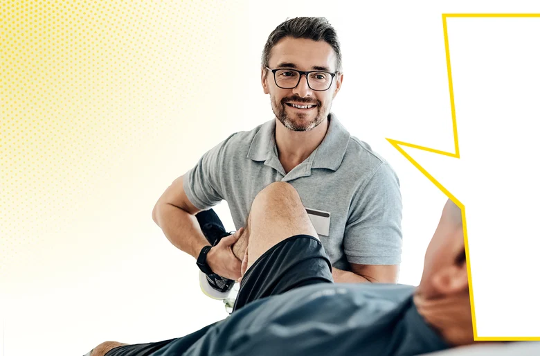Physiotherapeut mit Brille und grauem Poloshirt mobilisiert Bein von Patient. Gelber Rahmen rechts im Hintergrund.