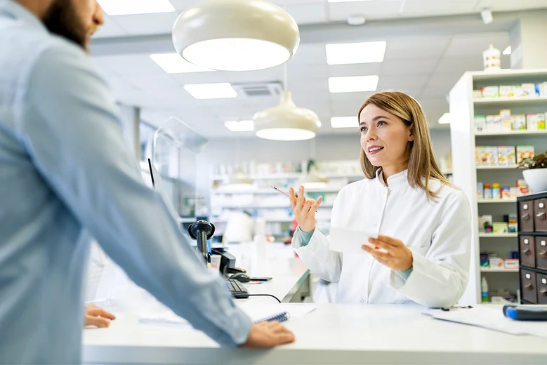 Apothekerin berät Kundin in moderner Apotheke: Freundliche Fachberatung am Tresen zu Medikamenten. Apotheker informieren über Anwendung, Wechselwirkungen und bieten Gesundheitschecks an.